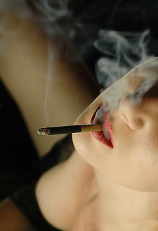 Brunette babe rubbing her boobs while smoking