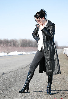 Badass babe in long leather coat smoking a ladylike Capri 120