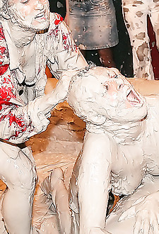 Naked girls wrestling fighting and covered in mud in a club