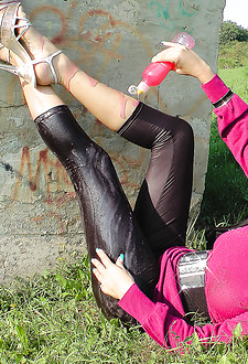 Pretty teen cutie under a bridge squirting cream on tits